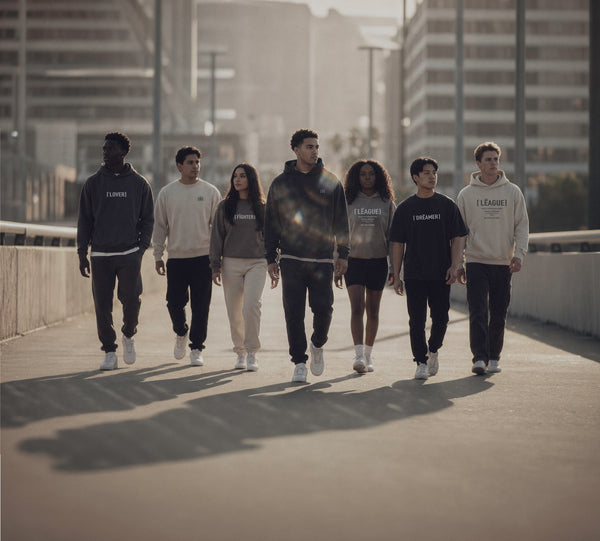 a group of people walking forward wearing humn league branded clothing