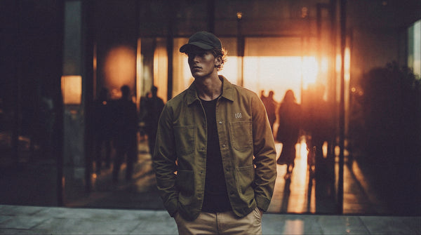 Man standing in a dimly lit hallway with a warm light source in the background